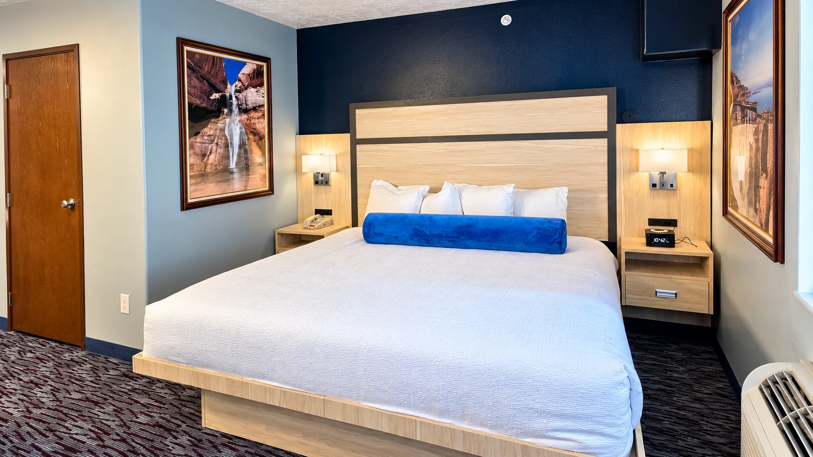 King bed seen from the entry door with framed landscape prints either side — Best Western Vernal Inn, Vernal Utah